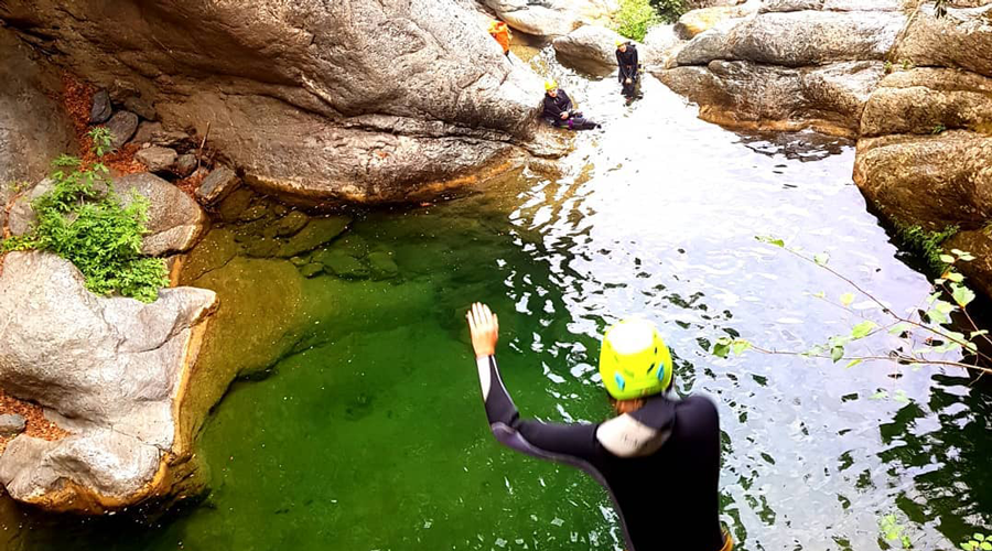 L'image capture l'énergie d'un groupe en pleine aventure de canyoning, transmettant l'excitation de la découverte et l'adrénaline de l'eau vive, entourée par la beauté des rochers et de la nature intacte.