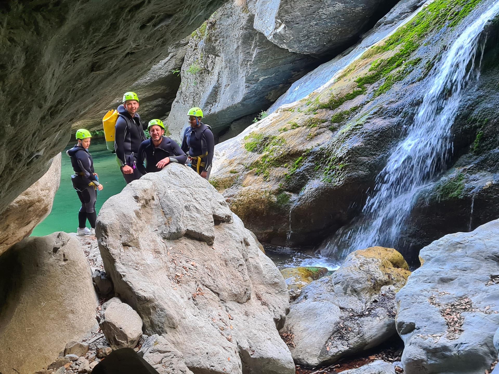 Aventure de canyoning avec un groupe d'amis explorant un magnifique canyon entouré de cascades et de nature verdoyante, pleine d'excitation et d'adrénaline.