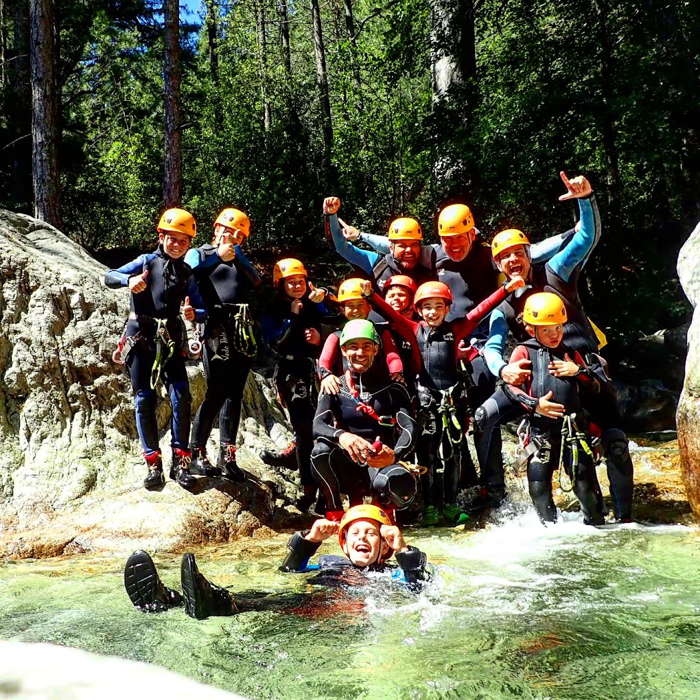 Cette image montre des personnes en pleine activité de canyoning, exprimant une joie contagieuse dans un environnement naturel splendide.