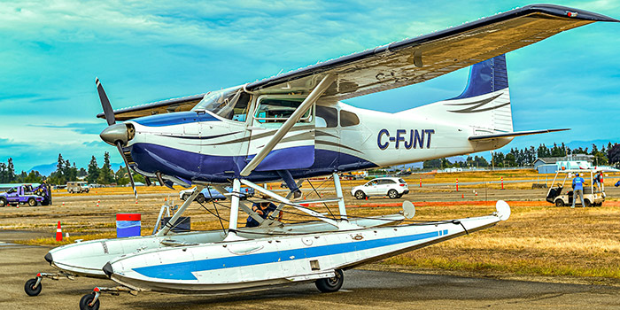Cette image d'un avion amphibie sur le tarmac traduit à la fois l'excitation et la sérénité associées à l'aviation. L'harmonie entre le ciel bleu et l'appareil invite à rêver d'évasion vers des destinations extraordinaires, tout en attendant le doux bruit des moteurs.