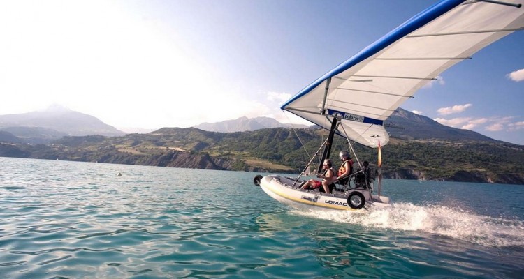 Image d'un bateau volant glissant sur un lac entouré de montagnes majestueuses, offrant une escapade palpitante dans un cadre naturel époustouflant.