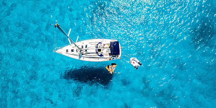 Un splendide bateau à voile navigue paisiblement sur une mer turquoise, invitant à l'évasion et à la détente en bonne compagnie.