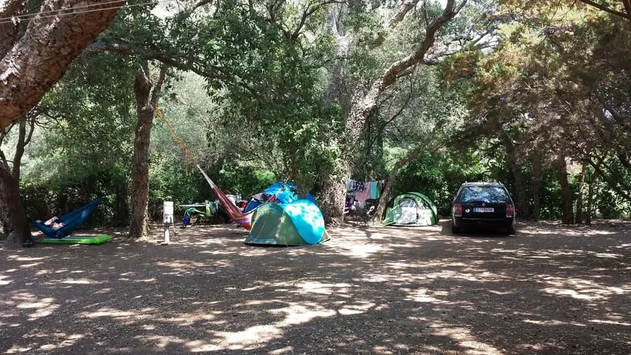 camping-a-casaiola-ombre-nature Emplacement de camping ombragé avec tentes et hamacs sous de grands chênes au Camping A Casaiola en Haute-Corse.